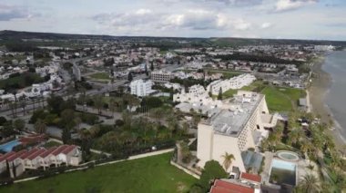 Deniz kenarındaki evlerin listesi. Kıbrıs Rum Kesimi 'nin Akdeniz' de yeşil çimleri ve yolu olan Lanaka deniz kasabasının havadan görünüşü. Gerçek zamanlı UHD 4K videosu.