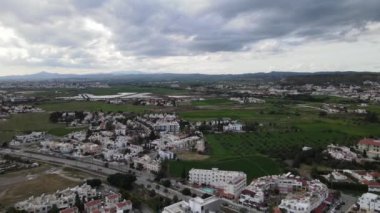 Deniz kenarındaki evlerin listesi. Kıbrıs Rum Kesimi 'nin Akdeniz' de yeşil çimleri ve yolu olan Lanaka deniz kasabasının havadan görünüşü. Gerçek zamanlı UHD 4K videosu.