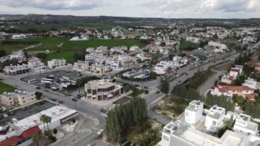 Deniz kenarındaki evlerin listesi. Kıbrıs Rum Kesimi 'nin Akdeniz' de yeşil çimleri ve yolu olan Lanaka deniz kasabasının havadan görünüşü. Gerçek zamanlı UHD 4K videosu.