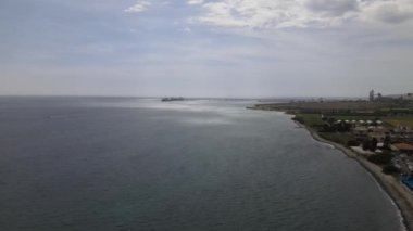 Deniz İskelesi 'nin havadan görünüşü, Akdeniz' in ön planındaki taş evler ve şehir binaları güneşli ve açık bir günde insansız hava aracı tarafından çekiliyor.