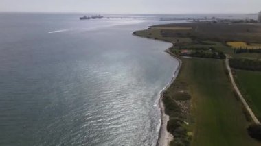 Deniz İskelesi 'nin havadan görünüşü, Akdeniz' in ön planındaki taş evler ve şehir binaları güneşli ve açık bir günde insansız hava aracı tarafından çekiliyor.