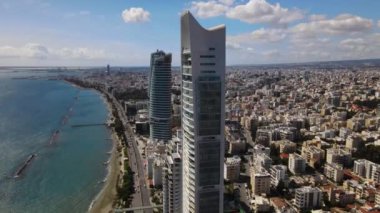 Kıbrıs Rum Kesimi 'nin Limasol kentinin hava manzarası. Seçilmiş Kişi, şehrin iş merkezindeki bir gökdelen binasıdır. Şehrin kıyı şeridinde üçlü bir bina. Yüksek kalite 4K görüntü