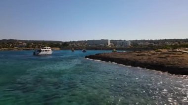 Etrafı turistik otellerle çevrili bir gemide tekne gezileri. Akdeniz 'de. Kıbrıs.
