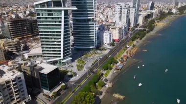 Açık bir günde Limasol 'un hava görüntüsü. İnsanoğlunun en güzel yaratılışının görkemli manzarası. Limasol, Kıbrıs üzerinde. Limasol 'un yüksek katlı cam yapılarıyla modern şehir manzarası. Deniz ve şehir sınırı.