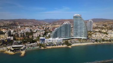 Açık bir günde Limasol 'un hava görüntüsü. İnsanoğlunun en güzel yaratılışının görkemli manzarası. Limasol, Kıbrıs üzerinde. Limasol 'un yüksek katlı cam yapılarıyla modern şehir manzarası. Deniz ve şehir sınırı.