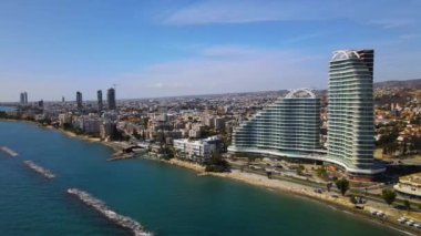 Açık bir günde Limasol 'un hava görüntüsü. İnsanoğlunun en güzel yaratılışının görkemli manzarası. Limasol, Kıbrıs üzerinde. Limasol 'un yüksek katlı cam yapılarıyla modern şehir manzarası. Deniz ve şehir sınırı.