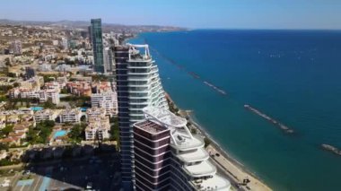 Açık bir günde Limasol 'un hava görüntüsü. İnsanoğlunun en güzel yaratılışının görkemli manzarası. Limasol, Kıbrıs üzerinde. Limasol 'un yüksek katlı cam yapılarıyla modern şehir manzarası. Deniz ve şehir sınırı.