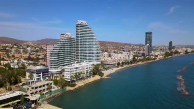 Açık bir günde Limasol 'un hava görüntüsü. İnsanoğlunun en güzel yaratılışının görkemli manzarası. Limasol, Kıbrıs üzerinde. Limasol 'un yüksek katlı cam yapılarıyla modern şehir manzarası. Deniz ve şehir sınırı.