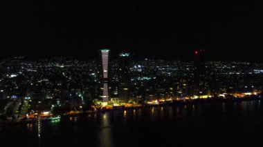 Gece şehir manzarası. Limasol 'un aydınlatılmış şehir cazibesini, modern mimariyi ve trafiği hava keşfi. Yüksek kalite 4K görüntü. Kıbrıs, Akdeniz