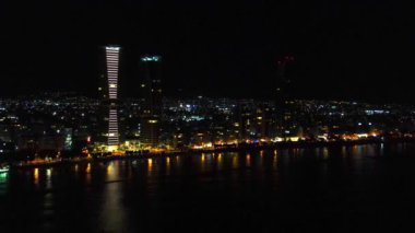 Gece şehir manzarası. Limasol 'un aydınlatılmış şehir cazibesini, modern mimariyi ve trafiği hava keşfi. Yüksek kalite 4K görüntü. Kıbrıs, Akdeniz