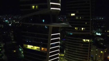 Gece şehir manzarası. Limasol 'un aydınlatılmış şehir cazibesini, modern mimariyi ve trafiği hava keşfi. Yüksek kalite 4K görüntü. Kıbrıs, Akdeniz