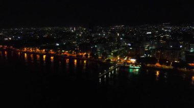 Gece şehir manzarası. Limasol 'un aydınlatılmış şehir cazibesini, modern mimariyi ve trafiği hava keşfi. Yüksek kalite 4K görüntü. Kıbrıs, Akdeniz