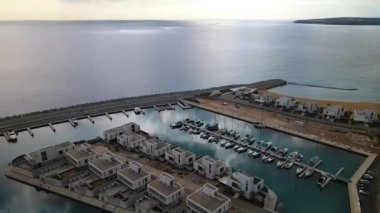 Ayia Napa Kıbrıs. Ayia Napa Marina 'nın kuş bakışı manzarası. Güneşli bir günde yüksek binalar ve marina. Akdeniz ve modern mimari. Denizin arka planına karşı doğa ve şehircilik.