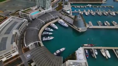 Ayia Napa Kıbrıs. Ayia Napa Marina 'nın kuş bakışı manzarası. Güneşli bir günde yüksek binalar ve marina. Akdeniz ve modern mimari. Denizin arka planına karşı doğa ve şehircilik.