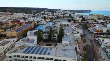 Kıbrıs, Ayia Napa. Kentin ve Akdeniz 'in kuş bakışı manzarası. Gündüz trafiği. Sahil kenti mimarisi. Beyaz evler ve güzel binalar.