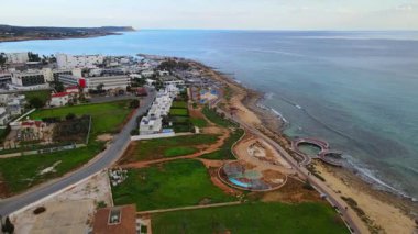 Kıbrıs, Ayia Napa. Kentin ve Akdeniz 'in kuş bakışı manzarası. Gündüz trafiği. Sahil kenti mimarisi. Beyaz evler ve güzel binalar.