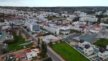 Kıbrıs, Ayia Napa. Kentin ve Akdeniz 'in kuş bakışı manzarası. Gündüz trafiği. Sahil kenti mimarisi. Beyaz evler ve güzel binalar.