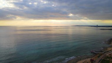 Şehirde deniz üzerinde güzel bir gün batımı. Ayia Napa Kıbrıs. Güneş Akdeniz 'deki bulutların arasından doğuyor. Kıyı şeridi.