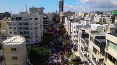 Limasol 'daki büyük karnaval geçidi. Kıbrıs Rum Kesimi: Şehirdeki insanların bir karnavalda kostüm giyip gösteri yapmalarının havadan görüntüsü.