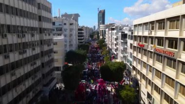 Limasol 'daki büyük karnaval geçidi. Kıbrıs Rum Kesimi: Şehirdeki insanların bir karnavalda kostüm giyip gösteri yapmalarının havadan görüntüsü.