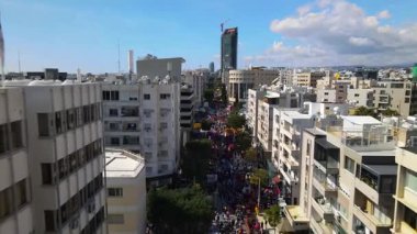 Limasol 'daki büyük karnaval geçidi. Kıbrıs Rum Kesimi: Şehirdeki insanların bir karnavalda kostüm giyip gösteri yapmalarının havadan görüntüsü.