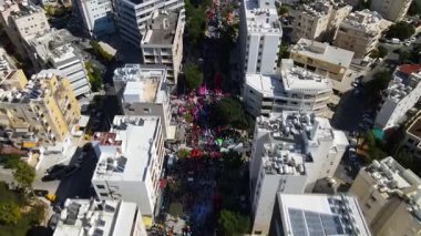 Limasol 'daki büyük karnaval geçidi. Kıbrıs Rum Kesimi: Şehirdeki insanların bir karnavalda kostüm giyip gösteri yapmalarının havadan görüntüsü.