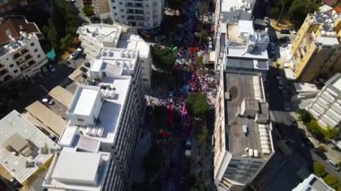 Limasol 'daki büyük karnaval geçidi. Kıbrıs Rum Kesimi: Şehirdeki insanların bir karnavalda kostüm giyip gösteri yapmalarının havadan görüntüsü.