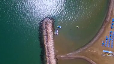 Sahildeki bir otelden yaz manzarası. Akdeniz ve tüm ihtişamıyla güneş. Plajlar ve kumsalda su dinlenmesi..