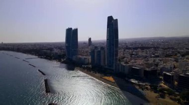Kıbrıs, Limasol 'da akşam üstü. Kıbrıs 'ın modern şehir mimarisi ve cam gökdelenlerinin havadan görünüşü. Kıbrıs 'ın Limasol kenti yakınlarında Akdeniz. Yüksek kaliteli görüntüler 4K