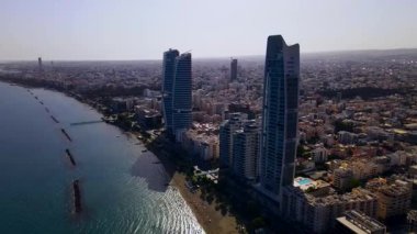 Kıbrıs, Limasol 'da akşam üstü. Kıbrıs 'ın modern şehir mimarisi ve cam gökdelenlerinin havadan görünüşü. Kıbrıs 'ın Limasol kenti yakınlarında Akdeniz. Yüksek kaliteli görüntüler 4K