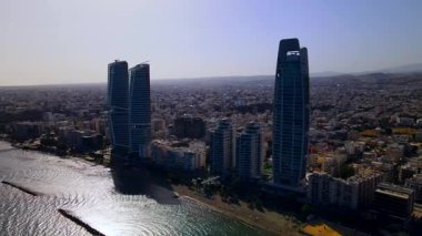 Kıbrıs, Limasol 'da akşam üstü. Kıbrıs 'ın modern şehir mimarisi ve cam gökdelenlerinin havadan görünüşü. Kıbrıs 'ın Limasol kenti yakınlarında Akdeniz. Yüksek kaliteli görüntüler 4K