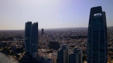 Kıbrıs, Limasol 'da akşam üstü. Kıbrıs 'ın modern şehir mimarisi ve cam gökdelenlerinin havadan görünüşü. Kıbrıs 'ın Limasol kenti yakınlarında Akdeniz. Yüksek kaliteli görüntüler 4K