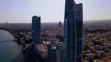 Kıbrıs, Limasol 'da akşam üstü. Kıbrıs 'ın modern şehir mimarisi ve cam gökdelenlerinin havadan görünüşü. Kıbrıs 'ın Limasol kenti yakınlarında Akdeniz. Yüksek kaliteli görüntüler 4K