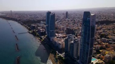 Kıbrıs, Limasol 'da akşam üstü. Kıbrıs 'ın modern şehir mimarisi ve cam gökdelenlerinin havadan görünüşü. Kıbrıs 'ın Limasol kenti yakınlarında Akdeniz. Yüksek kaliteli görüntüler 4K