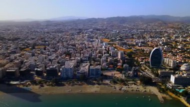 Kıbrıs, Limasol 'da akşam üstü. Kıbrıs 'ın modern şehir mimarisi ve cam gökdelenlerinin havadan görünüşü. Kıbrıs 'ın Limasol kenti yakınlarında Akdeniz. Yüksek kaliteli görüntüler 4K