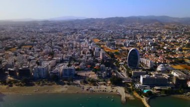 Kıbrıs, Limasol 'da akşam üstü. Kıbrıs 'ın modern şehir mimarisi ve cam gökdelenlerinin havadan görünüşü. Kıbrıs 'ın Limasol kenti yakınlarında Akdeniz. Yüksek kaliteli görüntüler 4K