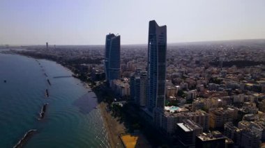 Kıbrıs, Limasol 'da akşam üstü. Kıbrıs 'ın modern şehir mimarisi ve cam gökdelenlerinin havadan görünüşü. Kıbrıs 'ın Limasol kenti yakınlarında Akdeniz. Yüksek kaliteli görüntüler 4K