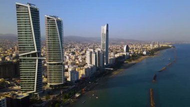Limasol binalarından, Cyprus 'tan yukarıdan bak. Kıbrıs' ın yüksek kulelerinden. Yaz günbatımı ve arka planda şehir trafiği olan Akdeniz