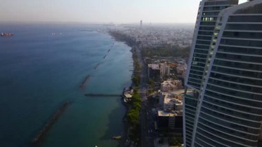 Limasol binalarından, Cyprus 'tan yukarıdan bak. Kıbrıs' ın yüksek kulelerinden. Yaz günbatımı ve arka planda şehir trafiği olan Akdeniz