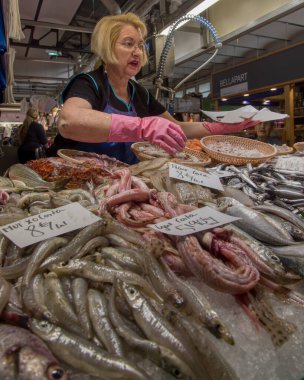 Bir market tezgahı satıcısı Mercat del Lleo 'da balık satar. Gironas' ın ünlü kapalı mekan pazarında. Yüksek kalite fotoğraf