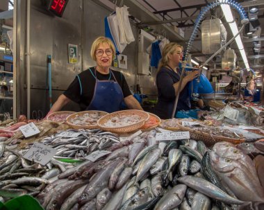 Bir market tezgahı satıcısı Mercat del Lleo 'da balık satar. Gironas' ın ünlü kapalı mekan pazarında. Yüksek kalite fotoğraf