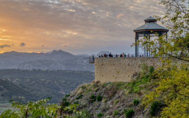 Ronda, Spain - 3rd November 2024: A view of the observation deck at Rondas Alameda del Tajo gardens at sunset. High quality photo clipart