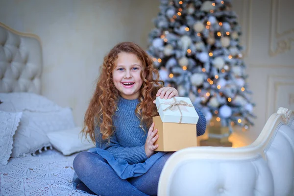 Charming Redhead teenage girl opens Christmas gift and happy. Christmas shopping. Festive atmosphere christmas day. Prepare surprise gift. Open gift. Happy moments. Winter holidays. Happy childhood.