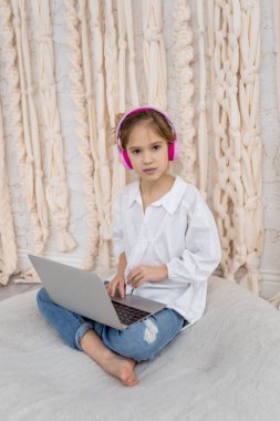 Teenage pupil using laptop notebook preparing for exams at home. Girl in headphone study online with video call, learn english language listen lecture. People, remote education, technology concept