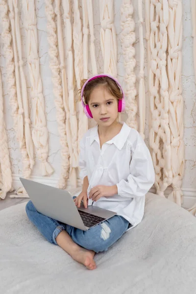 Teenage pupil using laptop notebook preparing for exams at home. Girl in headphone study online with video call, learn english language listen lecture. People, remote education, technology concept