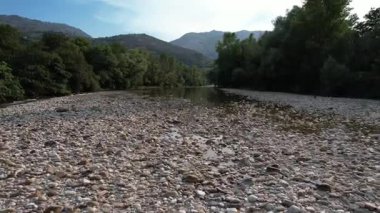 Cares River, Asturias 'ın alçak irtifada, nehir yatağı kayaları ve alçak su seviyesinde ilerleyen insansız hava aracı görüntüleri.