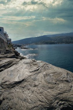 Andros Adası yakınlarındaki kayalık kıyı şeridi ve kristal berraklığında Ege Denizi suları.