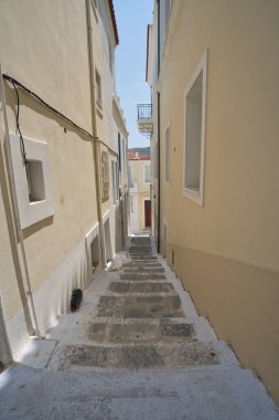 Chora, Andros Adası, Greec 'te beyaz boyalı evleri ve balkonları olan güneşli dar bir cadde.