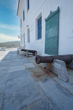 İki paslı tarihi top Chora, Andros, Greec 'teki beyaz bir binanın önünde duruyor.