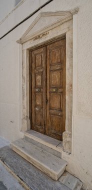 Eski ahşap çift kapılı süslü mermer çerçeveli ve geleneksel Chora, Andros, Greec evlerinde basamaklar
